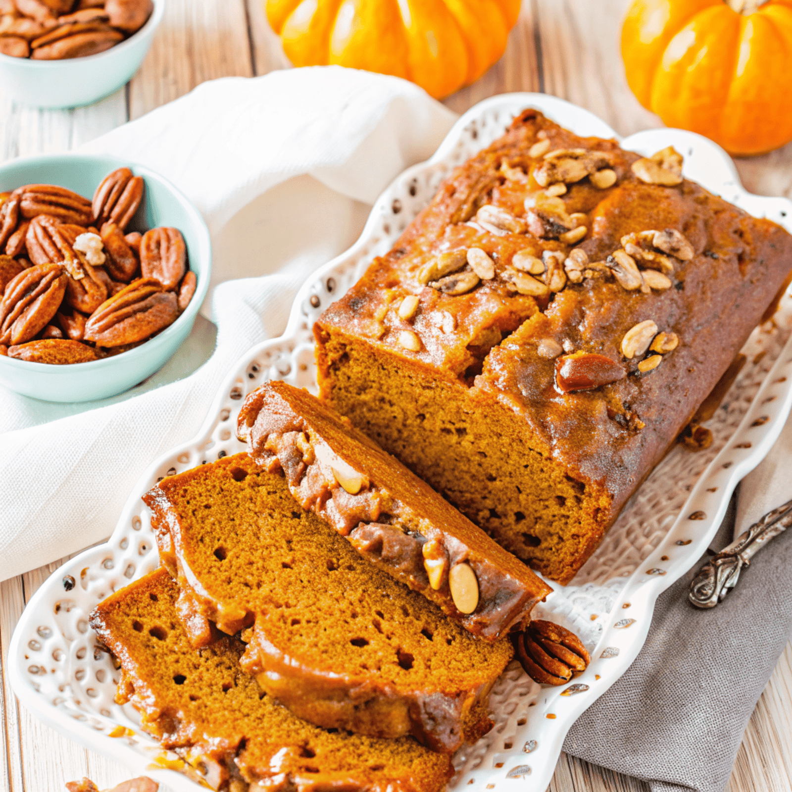 Slice of pumpkin bread with brown sugar glaze and pecans.